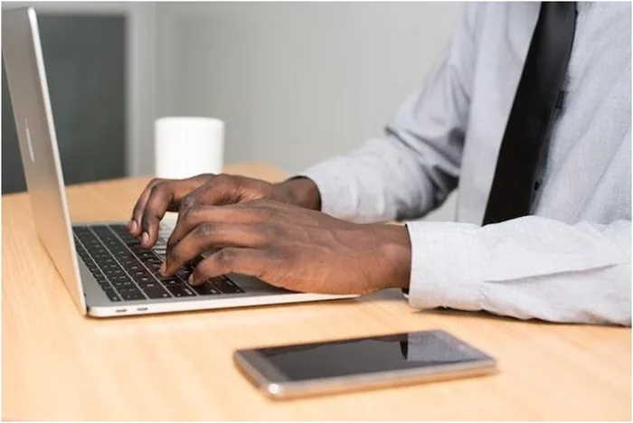 Hands typing on a laptop keyboard