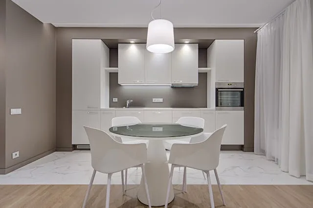 kitchen with grey brown walls white cupboards and kitchen table 