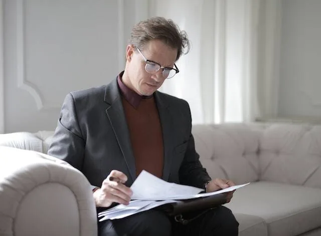 Person sitting on couch reading over report